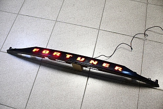 Планка Fortuner 2015 +, над задним номером тёмная , с подсветкой 